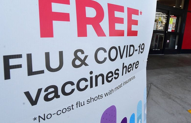 A woman arrives at a CVS pharmacy past a sign about free flu and COVID-19 vaccines on Jan. 14, 2022, in Monterey Park, California. (Frederic J. Brown/AFP via Getty Images/TNS) 124293654W 124293654W