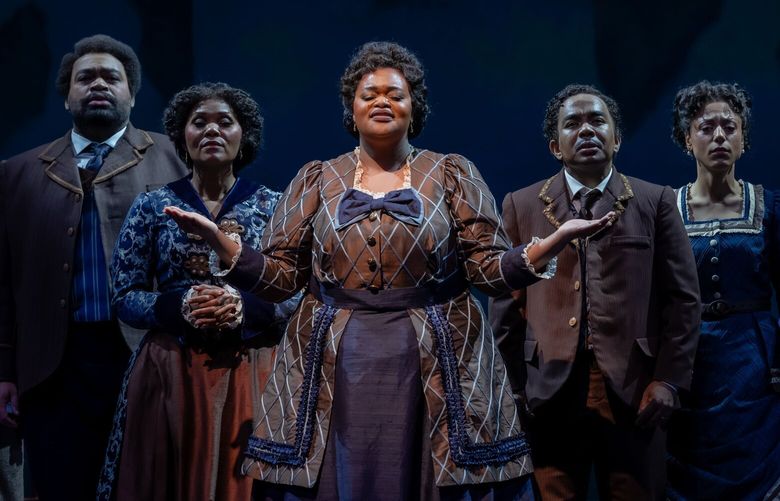 From left to right: Aubrey Allicock (Thomas Rutling), Darren Drone (Edmund Watkins), Aundi Marie Moore (Maggie Porter), Tiffany Townsend (America Robinson), Martin Bakari (Greene Evans), Sarah Joyce Cooper (Minnie Tate), and Lisa Arrindell (Ella Sheppard) in “Jubilee” at Seattle Opera.