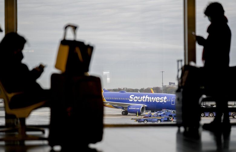 An airplane sits on the tarmac as travelers wait at Ronald Reagan Washington National Airport in Arlington, Va., Nov. 22, 2021. (Stefani Reynolds/The New York Times)