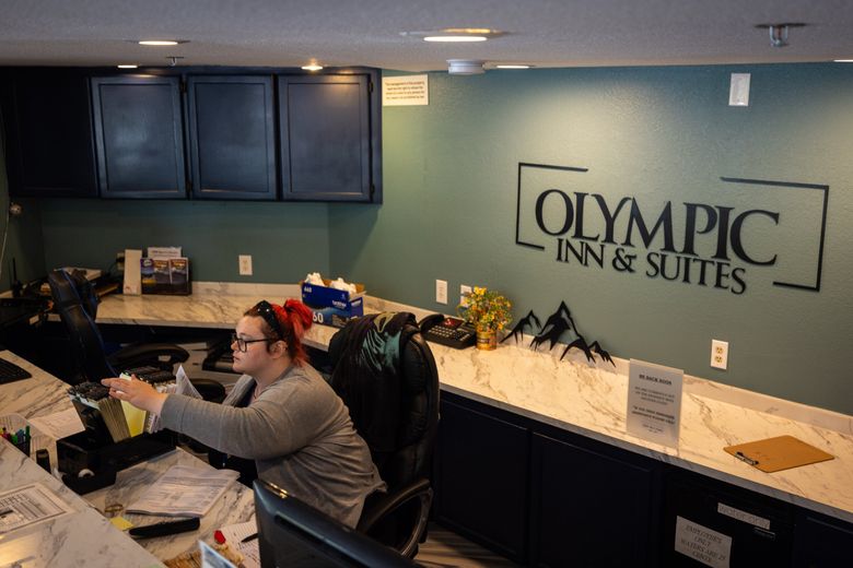 Samantha Tatman works at the front desk of Olympic Inn &#038; Suites. Despite the high cost of demolition and habitat problems along White Creek, WSDOT may still pursue the project to fulfill its court order. (Audrey Richardson / The Seattle Times)