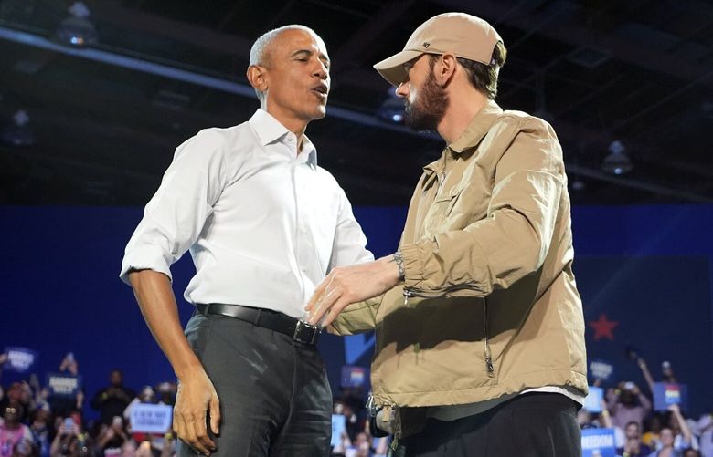 Rapper Eminem, right, greets former President Barack Obama, left, on stage at a campaign rally supporting Democratic presidential nominee Vice President Kamala Harris, Tuesday, Oct. 22, 2024, in Detroit. (AP Photo/Paul Sancya) MIPS512 MIPS512