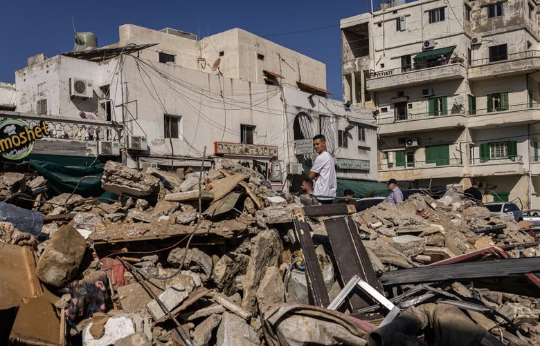 People search for survivors in the aftermath of an Israeli strike, which Lebanese officials say came without warning, killing at least 10 and wounding dozens more, in the Haret Saida area near Sidon on Wednesday, Oct. 30, 2024. The Israeli military said on Wednesday it had struck more than 100 sites across the country in the previous 24 hours, including here in the southern coastal city of Sidon, where attacks had been rare.  (Diego Ibarra Sanchez/The New York Times) XNYT0283 XNYT0283
