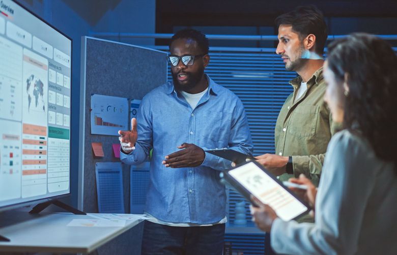 A team of multiethnic developers is meeting to review the data analysis of marketing from social media platforms.