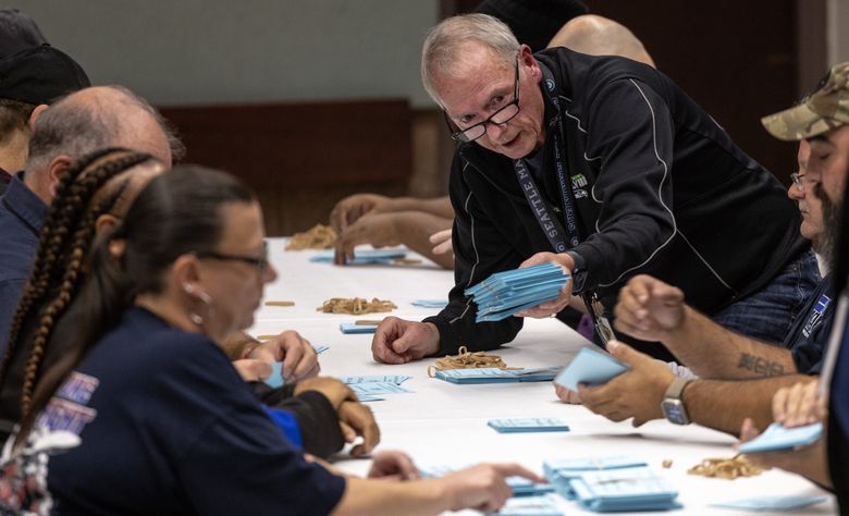 A Machinists union member passes along a stack of ballots cast during a vote on Boeing&#8217;s most recent offer to striking workers on Monday at the Machinists headquarters in South Park. (Nick Wagner / The Seattle Times)