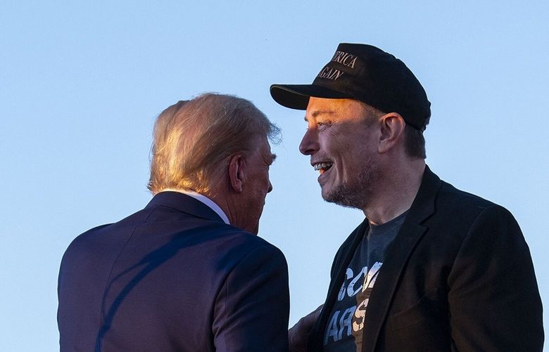 Donald Trump shakes hands with Elon Musk during a campaign rally in Butler, Pa. on Oct. 5, 2024. Investors believe that the electric car company led by Elon Musk will benefit from his support of the president-elect. (Doug Mills / The New York Times) 