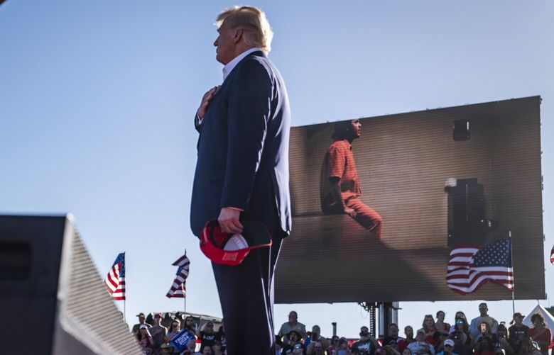 Former president Donald Trump listens as video from the Jan. 6, 2021, insurrection at the U.S. Capitol is played during a campaign rally at the Waco Regional Airport in March 2023. (MUST CREDIT: Jabin Botsford/The Washington Post)