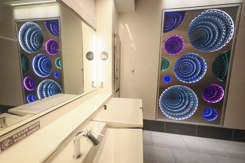 “Echoes of the Sound” by MiNHi England pictured inside a bathroom at Seattle–Tacoma International Airport. (Ivy Ceballo / The Seattle Times)