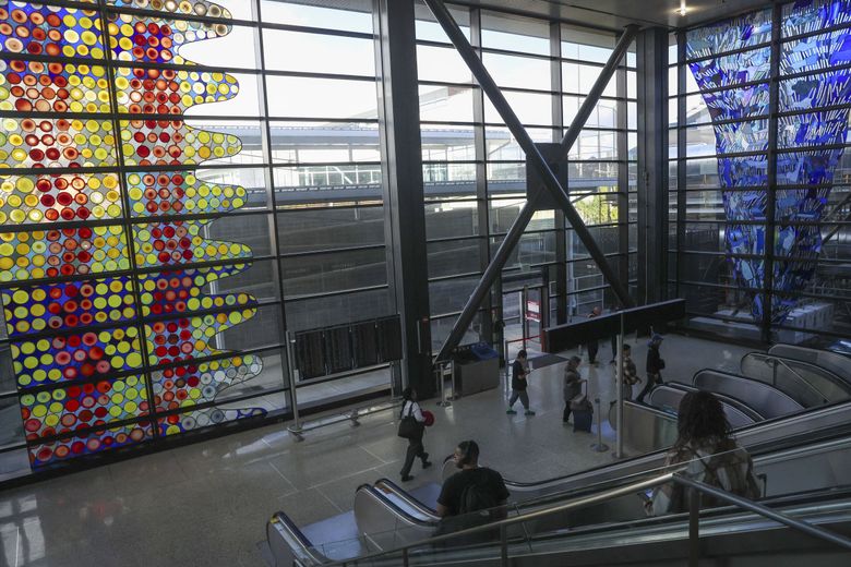 “Cow on Its Side” by Dick Weiss, left, pictured at Seattle–Tacoma International Airport. (Ivy Ceballo / The Seattle Times)