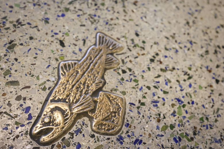 An easter egg fish carrying a suitcase makes up one of the fish depicted along a walkway at Seattle–Tacoma International Airport. (Ivy Ceballo / The Seattle Times)