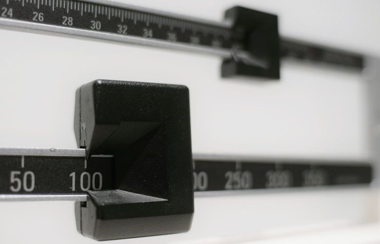 FILE – This April 3, 2018 file photo shows a closeup of a beam scale in New York. New research, published Tuesday, Oct. 16 in the Journal of the American Medical Association, suggests obesity surgery may dramatically lower the danger of heart attacks and strokes in people with diabetes. The study reinforces evidence that the benefits of stomach-shrinking surgery extend beyond weight loss.  (AP Photo/Patrick Sison, File)
