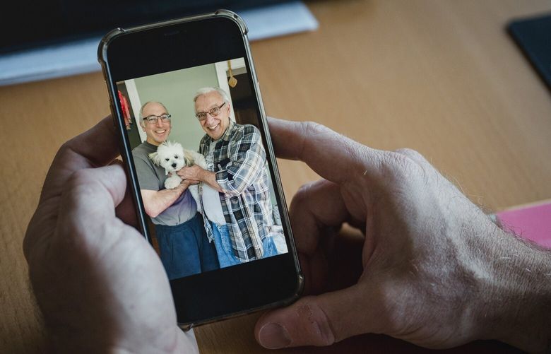 Chris Mancinelli looks at a 2021 photograph of him with his father, Alfred, who died last year, at his home in Collegeville, Pa., Oct. 22, 2024. Americans lost an estimated $12.5 billion to online criminals in 2023, according to the Federal Bureau of Investigation’s Internet Crime Complaint Center, including $652 million in losses tied to romance and confidence scams. (Hannah Yoon/The New York Times)
