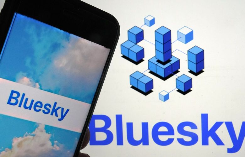 The app for Bluesky is shown on a mobile phone, left, and on a laptop screen on June 2, 2023. (AP Photo / Richard Drew) 