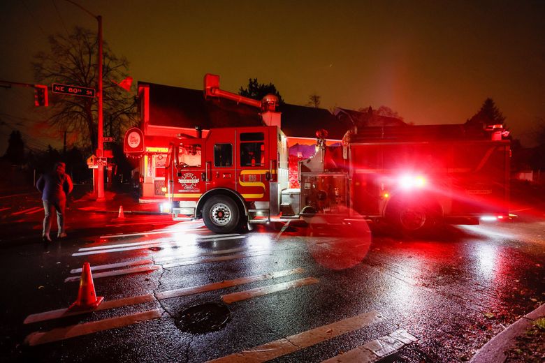 A firetruck blocks Northeast 80th Street at Roosevelt after power lines fell across the street Tuesday, Nov. 19 in Seattle. (Jennifer Buchanan / The Seattle Times)