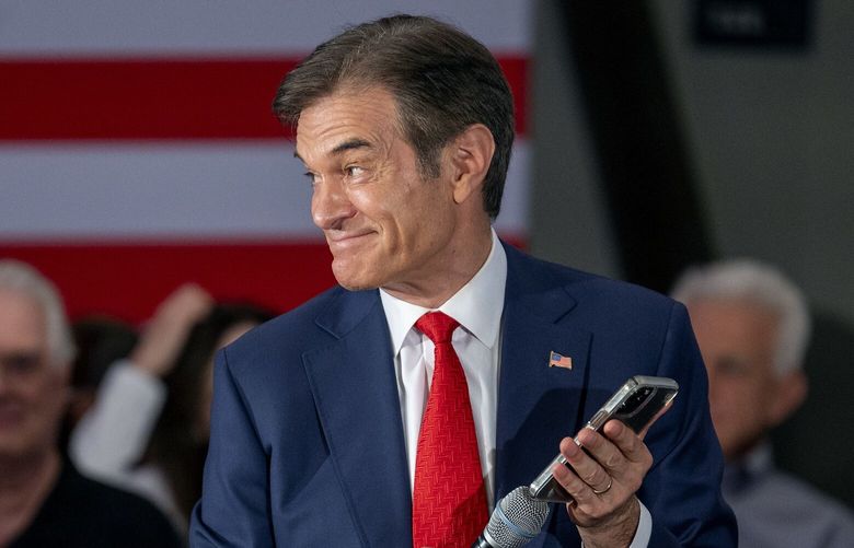 Mehmet Oz, seen during a campaign event when he was running for a U.S. Senare seat in Pennsylvania, holds his phone to the microphone as Donald Trump speaks. (Tom Gralish/The Philadelphia Inquirer/TNS) 127377622W 127377622W