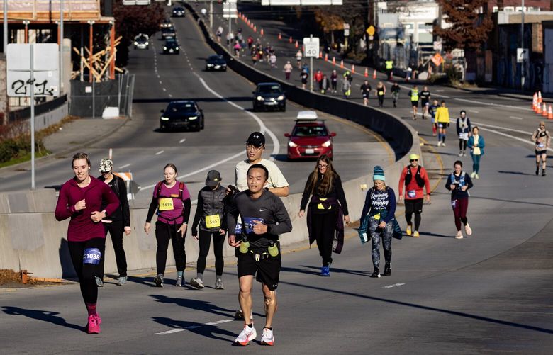 Runners make their way down Highway 99 Sunday, Nov. 26, 2023, during the Seattle Marathon and Half Marathon.