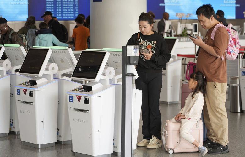 Travelers self-check at Delta Airlines counter at Los Angeles International Airport in Los Angeles, Wednesday, Nov. 27, 2024. (AP Photo/Damian Dovarganes) CADD306 CADD306