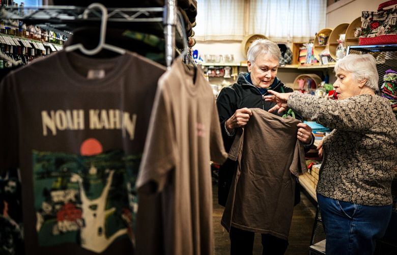 Sue Coburn, right, helps customer Joanne Ryan choose a Coburns’ General Store branded T-shirt at the business, a gathering place since the 1880s, in Strafford, Vt., Nov. 23, 2024. The future of the store, which looms large in the songs of Strafford famous son Noah Kahan, is uncertain, but fans of the folk-pop sensation cannot imagine his hometown without Coburns’ and his mother is helping lead an effort to save it. (Jacob Hannah/The New York Times)