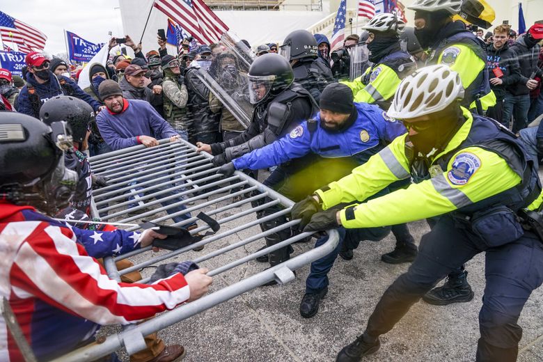 A violent mob of Trump supporters try to break through a police barrier at the Capitol in Washington. (John Minchillo / The Associated Press, 2021) 