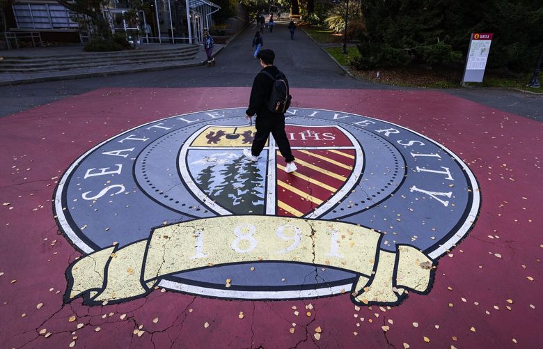 A student walks past Seattle University’s academic seal during a class change on the 50-acre campus on First Hill, Tuesday, Dec. 3, 2024, in Seattle.