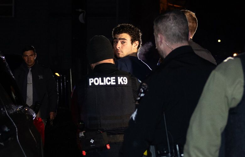 **EDS.: RETRANSMISSION TO PROVIDE ALTERNATE CROP ** Luigi Mangione is escorted by police to his arraignment at the Blair County Courthouse in Hollidaysburg, Pa., Monday, Dec. 9, 2024. The 26-year-old Maryland native was  arrested in Altoona, Pa., on gun charges and for questioning in connection with last week’s killing of a health insurance executive in Midtown Manhattan that prompted a manhunt up and down the East Coast, the New York Police Department said. (Rachel Wisniewski/The New York Times) XNYT0438 XNYT0438
