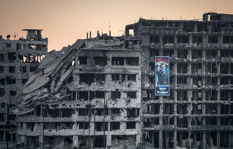 **EMBARGO: No electronic distribution, Web posting or street sales before TUESDAY 12:01 A.M. ET, DEC. 10, 2024. No exceptions for any reasons. EMBARGO set by source.** FILE — A poster for Syria’s President Bashar al-Assad hangs on a destroyed shopping mall in the war-ravaged city of Homs, Syria, June 15, 2014. (Sergey Ponomarev The New York Times) XNYT0109 XNYT0109