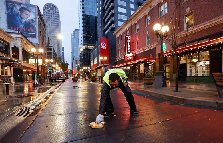 Michael Hegewald, assistant supervisor for the Metropolitan Improvement Project, picks up garbage as he cleans city streets at Pike Plaza at 1st Ave and Pike St. in Seattle on Wednesday, November 27, 2024. “Its an everyday work in progress,” he says. “We enjoy doing it.” Michael says they are in charge of cleaning 301 blocks downtown – from the waterfront to the freeway, from Denny Way to Royal Brougham – 363 days a year (only off for Thanksgiving and Christmas)
