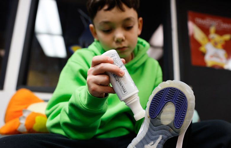 Antonio Phillips, 11, center, applies whitener to a pair of shoes he’s cleaning at Tabletop Village in the Chinatown International District in Seattle on Saturday, December 7, 2024.Middle school kids, age 11-12, who started their own company, Royalty Shoe Cleaners, clean shoes. 10% of their profit goes to charity, 15% goes towards supplies and the remaining money is split evenly among the kids for “Christmas cash” so they have spending money to buy gifts. The boys will be at Tabletop Village again this Sunday, Dec 15th from 1-3pm. Shoe cleanings range in price from a basic clean $5 to the full service at $8. Next donation will be to Sole for Soles