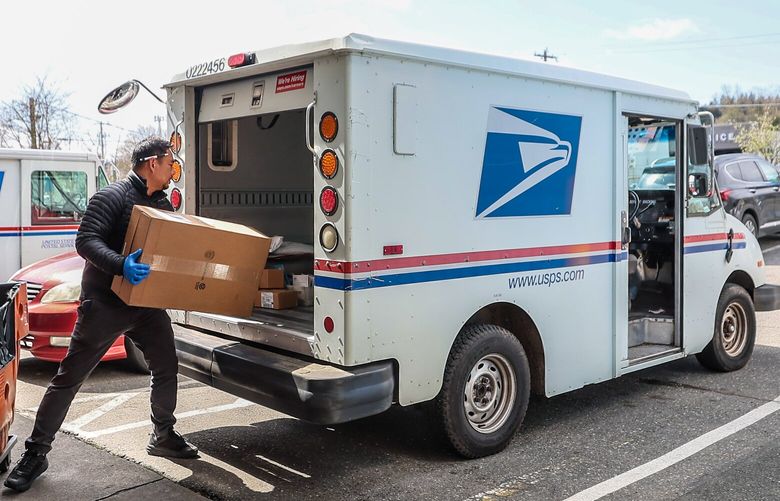 Michael Atendido loads a van for the day’s delivery Tuesday afternoon at the Lake City Postal Office in Seattle, Washington on April 11, 2023.