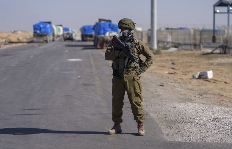 An Israeli soldier stands guard on the Palestinian side of the Kerem Shalom crossing between southern Israel and Gaza, Thursday, Dec. 19, 2024. (AP Photo/Ohad Zwigenberg) OZW201 OZW201