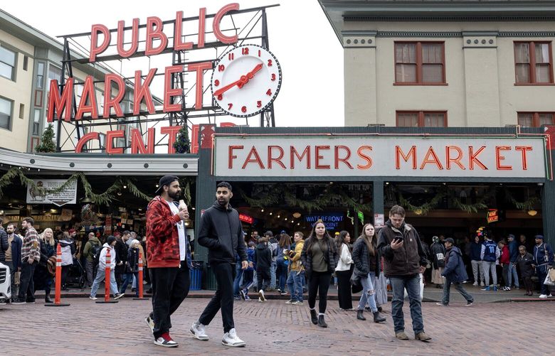 People flock to Pike Place Market for shopping on Monday, Dec. 23, 2024, in Seattle. (Nick Wagner / The Seattle Times)
