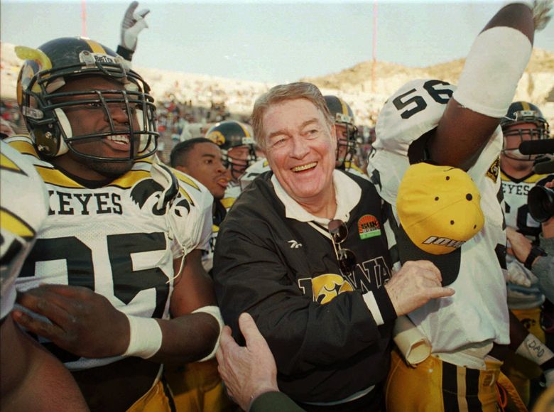 FILE &#8212; Iowa Hawkeyes head coach Hayden Fry, center, walks with  players Richard Willock, left, and Vernon Rollins (56) after the Hawkeyes defeated the Washington Huskies 38-18 in the Sun Bowl in El Paso, Texas, in this Dec. 29, 1995 photo. The worst of Fry&#8217;s 20 seasons with the Hawkeyes ended with an embarrassing 49-7 loss at Minnesota on Saturday, the Golden Gophers&#8217; most lopsided Big Ten win in 49 years. After the game, Fry said he had reached a decision about his coaching career. He declined to share it. (Tim Sharp / The Associated Press)