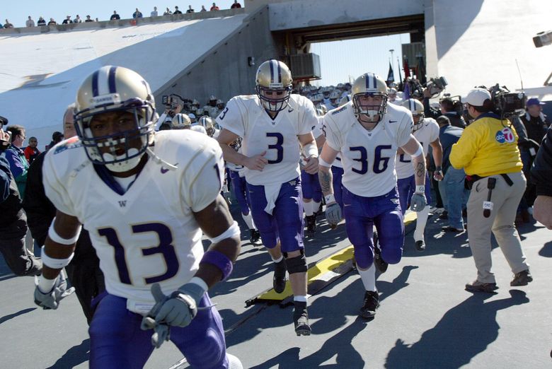 The Huskies, led by Nate Robinson (left) and Cody Pickett (3) storm out of the tunnel for the Sun Bowl. (Dean Rutz / The Seattle Times, 2002)