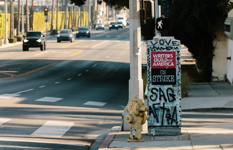 A poster and graffiti left over from the 2023 Writer’s Guild of America strike, in Los Angeles, Dec. 20, 2024. The economic outlook of the Los Angeles area, with a population larger than most states, has been clouded in recent years by events that have upended the entertainment industry. (Stella Kalinina/The New York Times) XNYT0949 XNYT0949