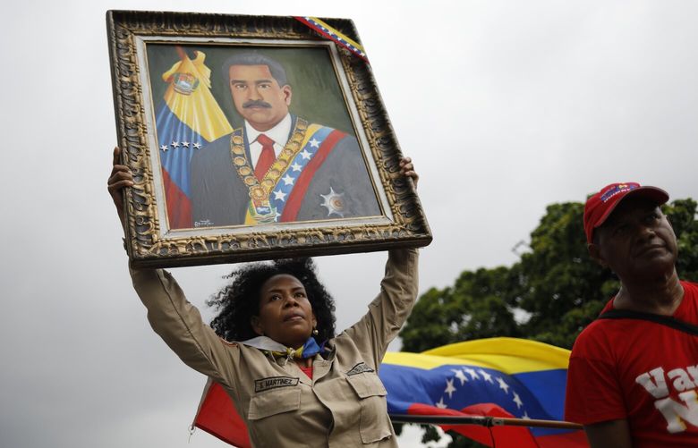 A member of the Bolivarian Militia holds up a painting depicting President Nicolas Maduro during a rally celebrating Maduro’s July 28 reelection, in Caracas, Venezuela, Saturday, Sept. 28, 2024. (AP Photo/Cristian Hernandez) LGK717 LGK717