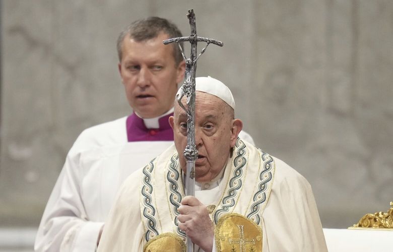 Pope Francis is flanked by Vatican Master of Ceremonies, Bishop Krysztof Marcjanowicz, left, as he arrives for a mass in St. Peter’s Basilica at The Vatican on New Year’s Day, Wednesday, Jan. 1, 2025. (AP Photo/Andrew Medichini) XDS115 XDS115