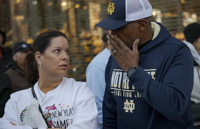 People react at the intersection of Bourbon Street and Canal Street during the investigation after a pickup truck rammed into a crowd of revelers early on New Year’s Day, Wednesday, Jan. 1, 2025, in New Orleans. (AP Photo/Matthew Hinton) LAMH167 LAMH167