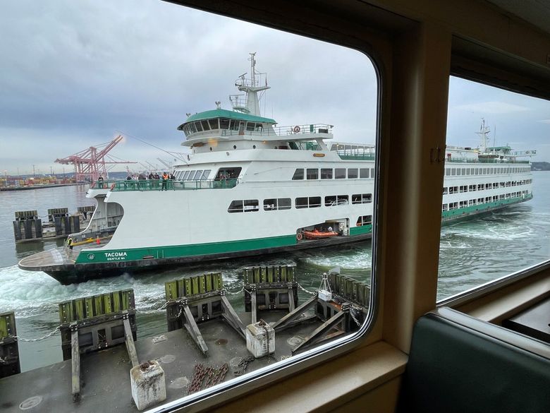 The M/V Tacoma, seen here through another ferry’s windows, approaches Colman Dock in Seattle. (Josh Farley / The Seattle Times)