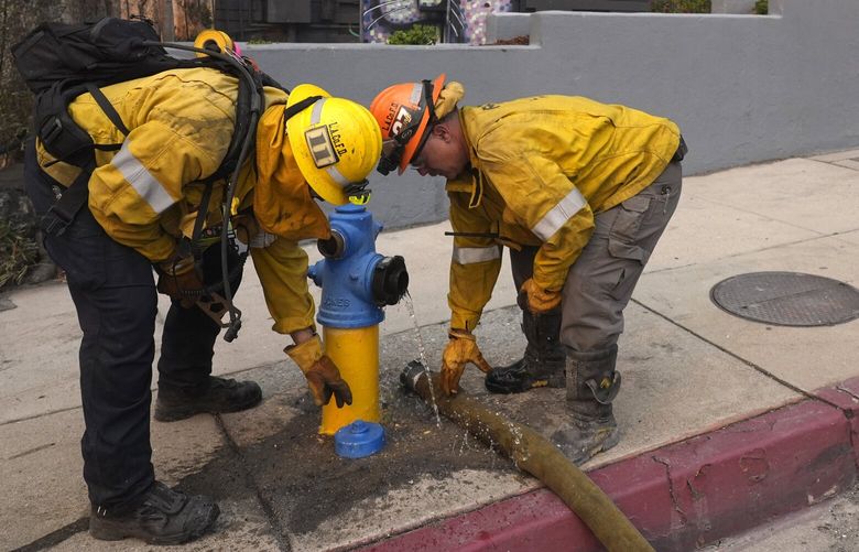Firefighters work a hydrant in front of the burning Bunny Museum, Wednesday, Jan. 8, 2025, in the Altadena section of Pasadena, Calif. (AP Photo/Chris Pizzello) CACP314 CACP314