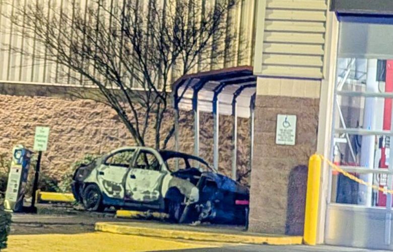Crime scene tape surrounds a burned car Tuesday at the Costco at Lakewood Crossing in Marysville.