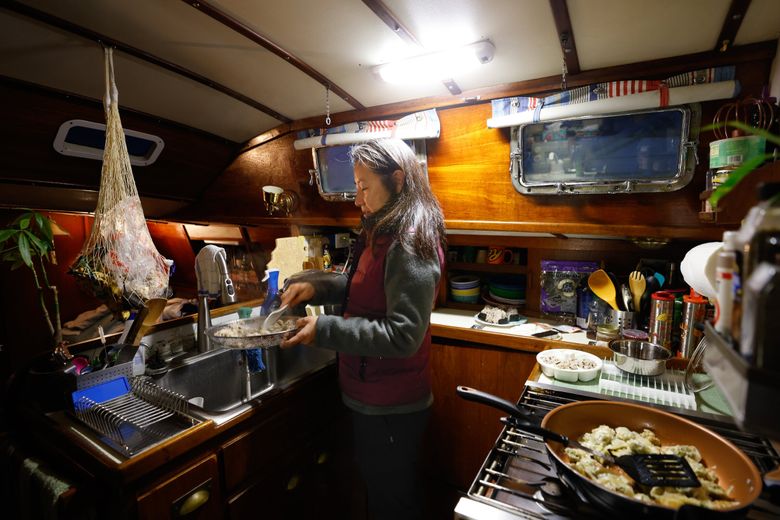 Rie DePaula prepares breakfast aboard her family&#8217;s 53-foot sailboat at Shilshole Bay Marina. She misses having a normal kitchen: “It’s kind of small and very inconvenient.” (Karen Ducey / The Seattle Times)