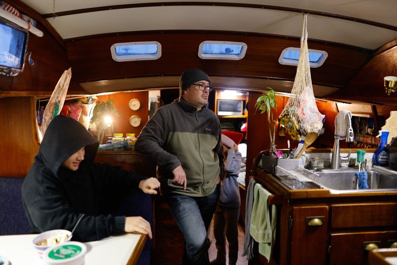 Aiden, left, his dad, Michael DePaula wait for breakfast. They name their sailboat “Sumebamiyako,” a Japanese  saying that translates to “Home is where you make it.” (Karen Ducey / The Seattle Times)