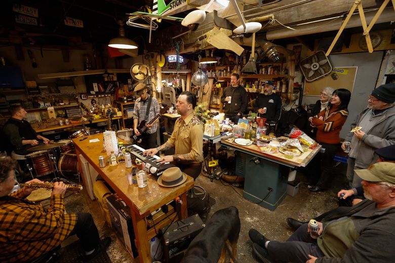 Ryan Currier plays the keyboards with his band while others party and ring in the New Year in a woodshop they call the Rocket Shop at Sagstad Marina. (Karen Ducey / The Seattle Times)