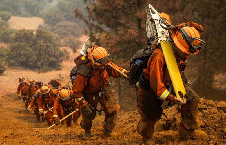 FILE –Inmate firefighters clearing a fire line on the Walbridge Fire near Healdsburg, Calif., during the LNU Complex fire, Aug. 23, 2020. Hundreds of incarcerated people are firefighting in Los Angeles. They usually make up to $10.24 a day, and receive an additional $1 for each hour that they battle the deadly blazes. (Max Whittaker/The New York Times)