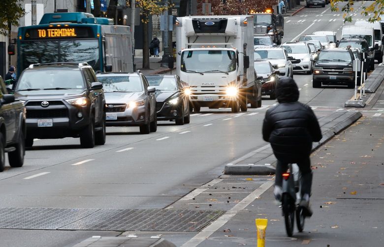 A confluence of transportation options exist near Westlake in downtown Seattle with the protected bike lanes, buses and cars, with pedestrians on the sidewalk at 4th Ave and Pine in Seattle, on Friday December 20, 2024. The City Council has asserted greater control over transportation spending dollars connected to the $1.55 billion levy passed in November by voters.