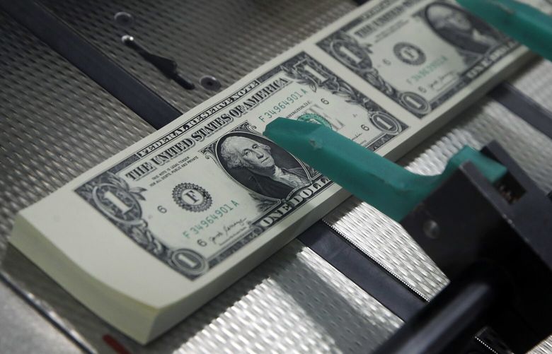 New $1 bills are cut and stacked at the Bureau of Engraving and Printing in Washington, D.C., in 2017. (AP Photo / Jacquelyn Martin) 