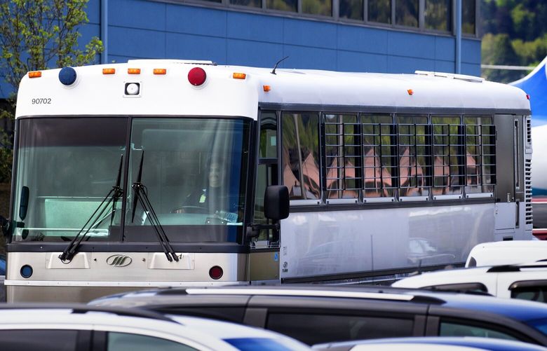 A bus with barred windows carrying detained immigrants from the plane in the background leaves Boeing Field around noon on Tuesday. The charter flight from Phoenix was operated for Immigration and Customs Enforcement (ICE).

Photographed on April, 23, 2019. 210018 210018