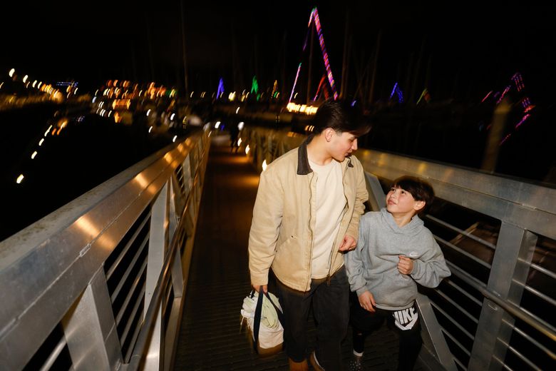 Aiden, left, and Ze DePaula joke around while walking up the dock toward the showers at Shilshole Bay Marina. (Karen Ducey / The Seattle Times)