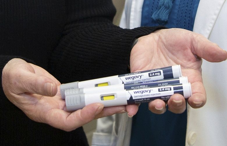 Patient Lory Osborn (left) holds Wegovy pens used in her treatment with Dr. Laura Davisson, director of the Medical Weight Management at West Virginia University in Morgantown, W.Va., Monday, Dec. 2, 2024. (AP Photo/Kathleen Batten) WVKB109 WVKB109