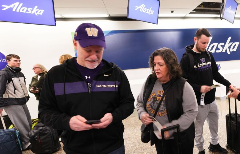 “It all worked out, We’re still getting there,” says Kyle Kurfess second from right who is traveling with Jay Haynie, left, Kelly Haynie, left center, and Isabel Haynie, right on their way to Houston for the Husky football game at SeaTac Airport in Seattle on Saturday, January 6, 2024. Their flight was cancelled and they rebooked through Albuquerque. “Next stop Houston!” exclaims Jay Haynie. Alaska Airlines cancels more than 100 flights after grounding Boeing fleet. 225904