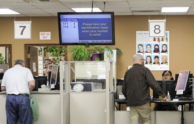 Customers wait for service at the Washington state Dept. of Licensing office in Lacey, Wash., Friday, June 22, 2018. Some Washington licenses and identification cards will soon be marked with the words “federal limits apply” as the state moves to comply with a federal law that increased rules for identification needed at airports and federal facilities. (AP Photo/Ted S. Warren) WATW202